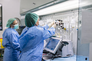 Pharmazeutinnen ordnen Tropfen auf einem Gestell im Labor eines Krankenhauses an - DGOF01358