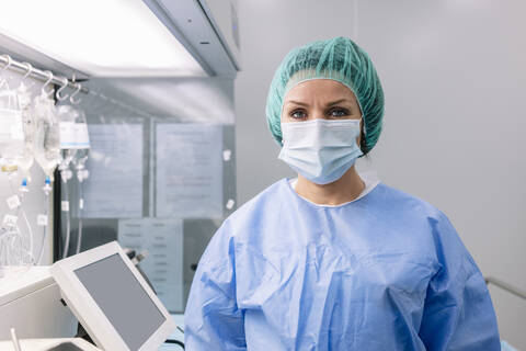 Female pharmacist wearing medical scrubs standing in laboratory stock photo