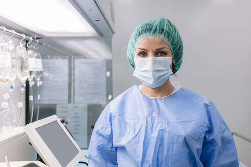 Female pharmacist wearing medical scrubs standing in laboratory - DGOF01363