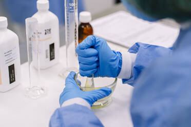 Close-up of female scientist holding bottle while standing in laboratory at hospital - DGOF01377