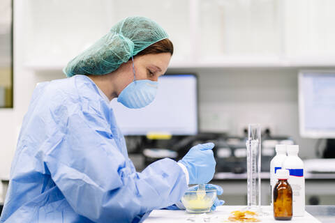 Female pharmacist preparing medicine in mortar on table at laboratory stock photo