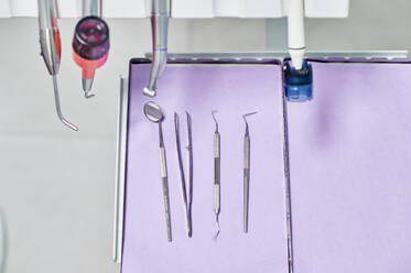 Oben ein Satz sauberer zahnärztlicher Werkzeuge, die auf einer Serviette auf einem Tablett in einer modernen Klinik liegen - ADSF15038