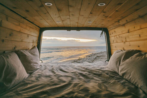 Blick auf den Sonnenuntergang aus den offenen Türen eines Sprinter-Vans in Baja, Mexiko. - CAVF88728