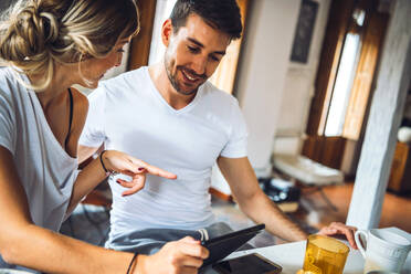 Young couple sitting at table and having breakfast at home - EHF00911