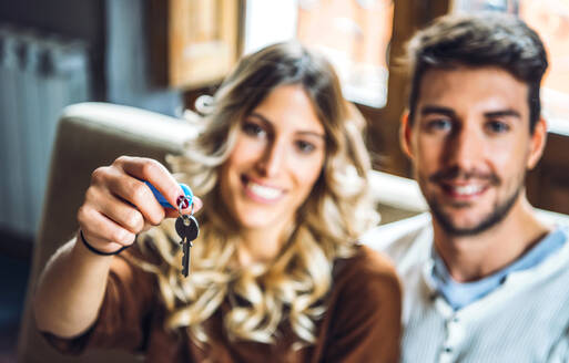 Porträt eines glücklichen jungen Paares mit den Schlüsseln des neuen Hauses - EHF00925