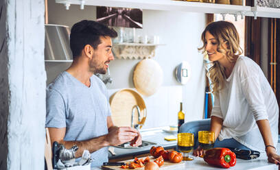 Junger Mann bereitet mit Freundin in der Küche zu Hause Essen zu - EHF00928