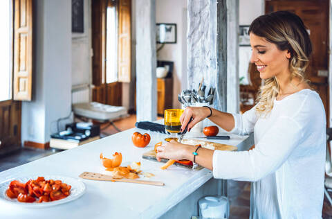 Beautiful young woman smiling and chopping vegetables for dinner stock photo