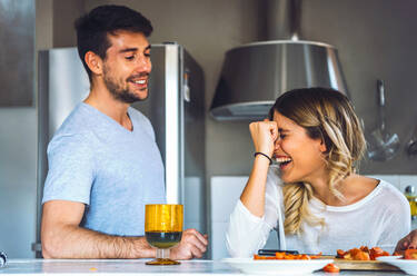 Lachende junge Frau mit Freund in der Küche zu Hause - EHF00943