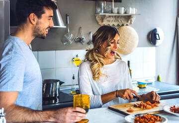 Glückliches junges Paar bei der Zubereitung von Speisen in der Küche zu Hause - EHF00944