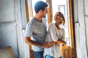 Affectionate young couple dancing in living room at home - EHF00953