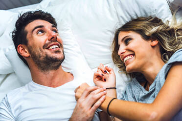 Happy young couple lying in bed at home - EHF00989