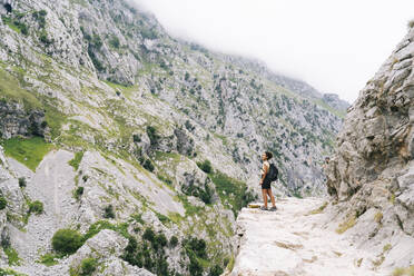 Young woman standing on the mountain path at Ruta Del Cares, Asturias, Spain - DGOF01386