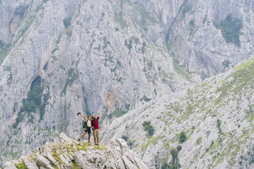 Carefree couple admiring the view while standing on mountain at Ruta Del Cares, Asturias, Spain - DGOF01392