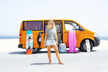 Blond hair woman standing at beach on sunny day - JCMF01331