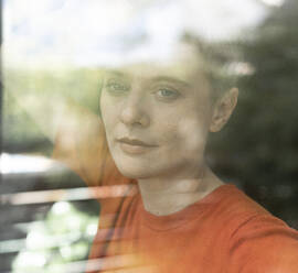 Close-up of thoughtful mid adult woman at home seen through window - UUF21301