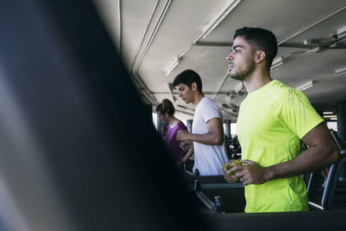 Athleten laufen auf Laufbändern im Fitnessstudio - ABZF03284