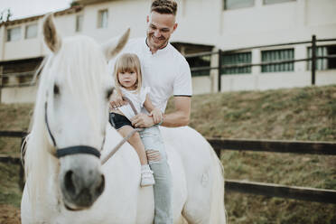 Lächelnder Vater mit Tochter auf Pferd - GMLF00575