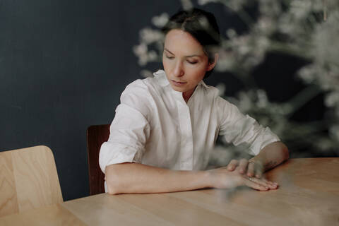 Thoughtful woman sitting at table in restaurant stock photo