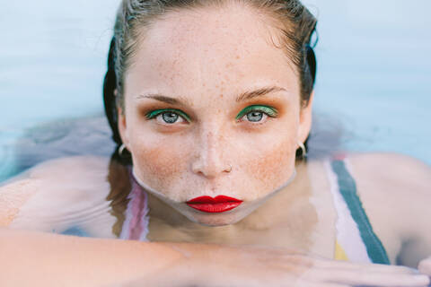 Close-up of a brunette girl with long hair on a stairs in the pool stock photo