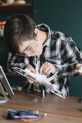 Boy making drone on table at home - ALBF01520