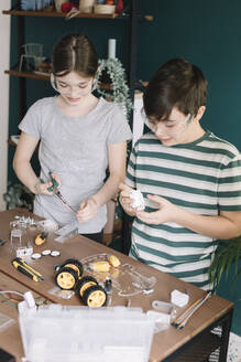 Geschwister bauen Roboterspielzeug auf dem Tisch zu Hause - ALBF01534
