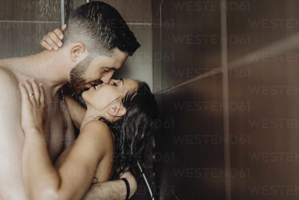 Naked romantic couple kissing each other on lips in bathroom stock photo