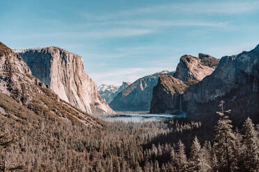 Spektakuläre Landschaft des Yosemite Valley mit einem von Wald und felsigen Bergen umgebenen See unter bewölktem blauem Himmel an einem sonnigen Frühlingstag in Kalifornien - ADSF15244