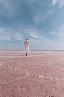 Nachdenklicher, entspannter Tourist, der die ungewöhnliche Szenerie des rosa Salzsees genießt - ADSF15271