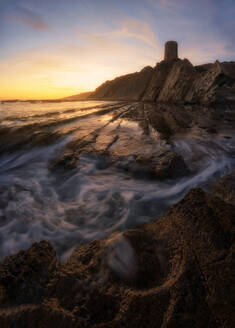 Spektakuläre Landschaft von Turm auf Felsen auf dem Hintergrund der bunten Sonnenuntergang in Cadiz - ADSF15304