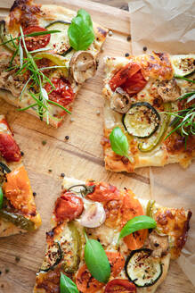 Von oben: schmackhafte vegetarische Pizza mit Kirschtomaten und Pilzen, garniert mit frischem Basilikum und Rosmarin - ADSF15323