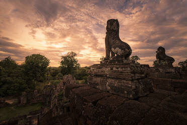 Spektakuläre Szenerie eines traditionellen buddhistischen Tempels mit Tiermonumenten vor dem Hintergrund eines herrlichen Sonnenuntergangs in Kambodscha - ADSF15392
