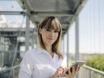 Close-up of confident businesswoman using digital tablet in greenhouse - JOSEF01630