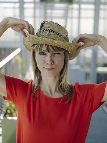 Close-up of businesswoman wearing hat while standing in plant nursery stock photo