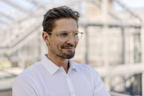 Close-up of thoughtful male professional wearing eyeglasses in plant nursery stock photo