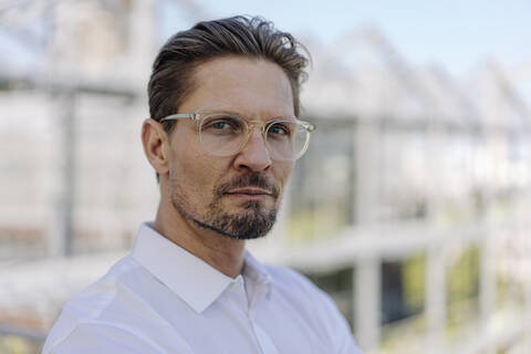 Close-up of serious male professional wearing eyeglasses in plant nursery stock photo