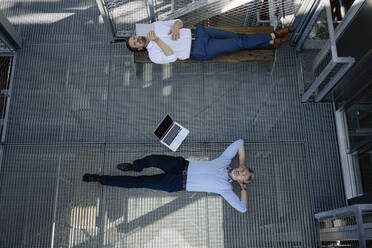 Male colleagues lying in greenhouse - JOSEF01869