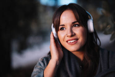 Attraktive Frau hört Musik über Kopfhörer im Wald - MRRF00387