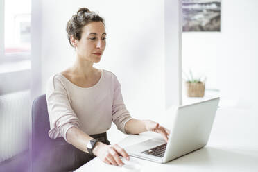 Geschäftsfrau mit Laptop auf dem Tisch - JOSEF01891