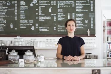 Selbstbewusste Besitzerin an der Theke eines Cafés - JOSEF01926