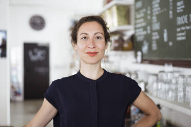 Close-up of confident female entrepreneur standing in restaurant - JOSEF01929