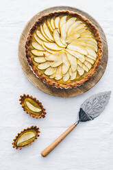 From above yummy freshly baked apple pie in casserole dish decorated with green apple slices and placed on table with white cloth - ADSF15448