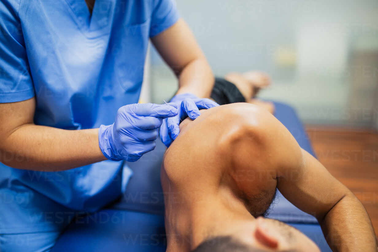 From above of crop faceless sports medicine doctor in sterile