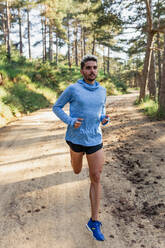 Determined man running on nature during workout - ADSF15473