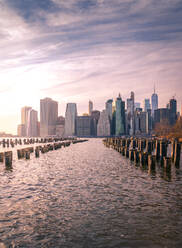 Die Skyline von Manhattan und die Pfähle des berühmten Brooklyn Bridge Park bei Sonnenuntergang - ADSF15494