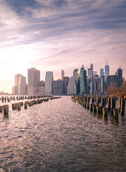 Manhattan skyline and poles of famous Brooklyn Bridge Park at sunset time - ADSF15494