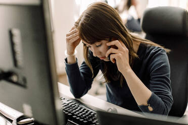 Computerprogrammierer im Gespräch am Telefon am Arbeitsplatz - MASF19488