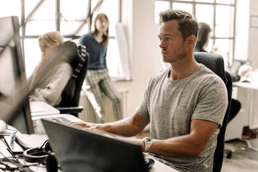 Male entrepreneur working on computer at workplace - MASF19491