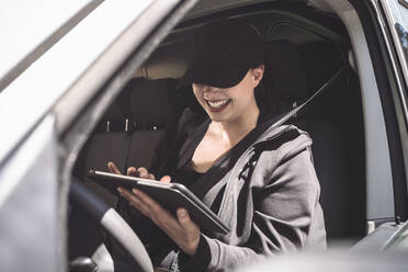 Lächelnde Fahrerin mit digitalem Tablet im Lkw - MASF19525