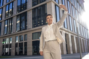 Businesswoman taking selfie while standing against modern office building - VPIF02988