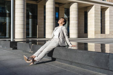 Businesswoman relaxing while sitting on bench in city - VPIF03004